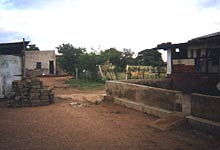 houses on dirt street with some construction and bricks