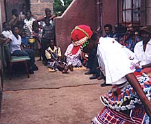 group of people clapping and one girl dancing in red fringed skirt