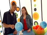 photo of hosts michael and mariko holding a balloon over a candle