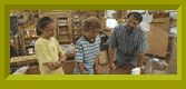 Anna and Noah with carpenter, Norm Abram, in a workshop.