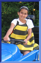 Julia wearing a bumble bee costume and driving a tractor.