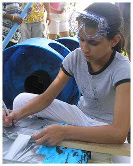 Julia wearing goggles and drawing with a marker.