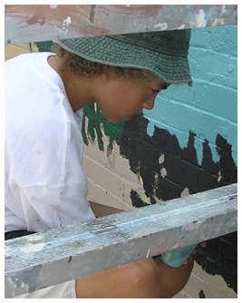 Noah painting a brick wall.