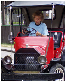 Noah in an old red car.