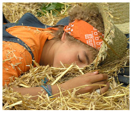 Noah lying face down in a pile of hay.