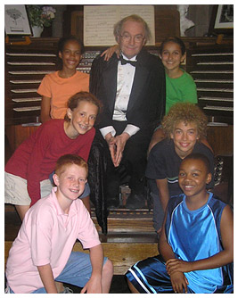 Taylor, Julia, Anna, Noah, Brian, and Khalil beside an older man wearing a tuxedo.