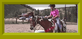 Madi rides a horse in a corral.