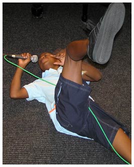 Mike lying on the floor singing into a microphone.