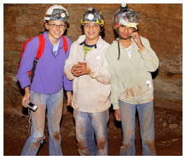 Bridget, Rosario, and Nina in a cave wearing their head lamps.
