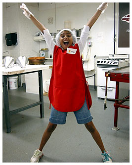 Nina at the chocolate factory in her red apron, plastic gloves, and hair net.