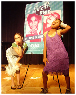 Noel and Harsha posing in their singing costumes with the Fetch! Star sign.