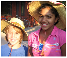 Sam and Harsha wearing straw hats.