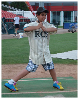 Sterling holds a baseball bat at home plate.