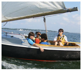 Isaac, Bethany, and Sterling ride in a sailboat.