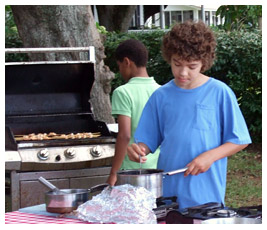 Jay and Marc cook outdoors with a grill.