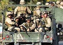 A photo of soldiers riding on a truck in Iraq