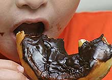 A kid eating a chocolate donut