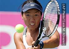 Vania King grits her teeth as she slams a tennis ball