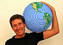 Nathan Sawaya holds up a Lego Earth