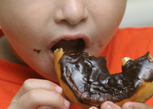Photo of a child eating a doughnut